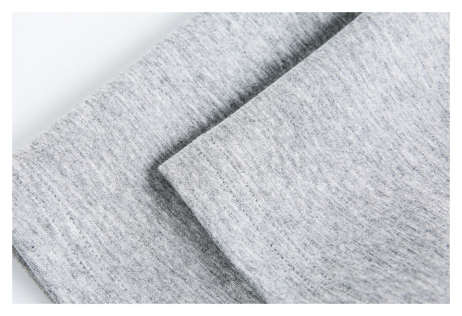 Close-up of gray heather knit fabric folded to show a stitched edge.