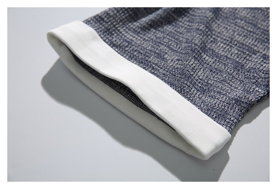 Close-up of the white sleeve cuff and gray-blue textured fabric.