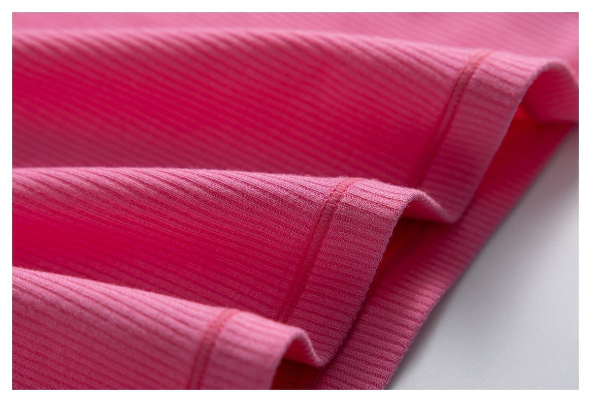 Close-up of folded edges and stitching on pink ribbed fabric.