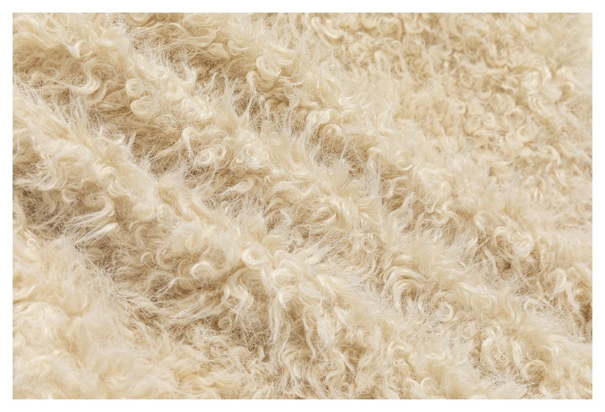 Extreme close-up of the cream jacket's curly, textured fleece.