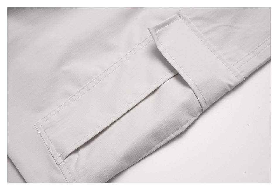 Close-up of the off-white cargo pocket flap and double-stitched pocket edges.