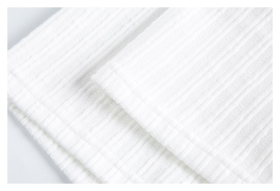 Close-up of layered white knit fabric with prominent raised horizontal ribbed texture.