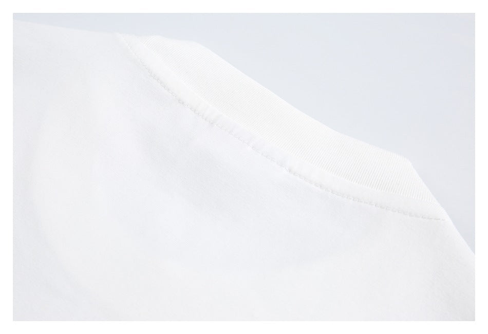 Close-up of the ribbed neckline and shoulder seam of a white T-shirt.