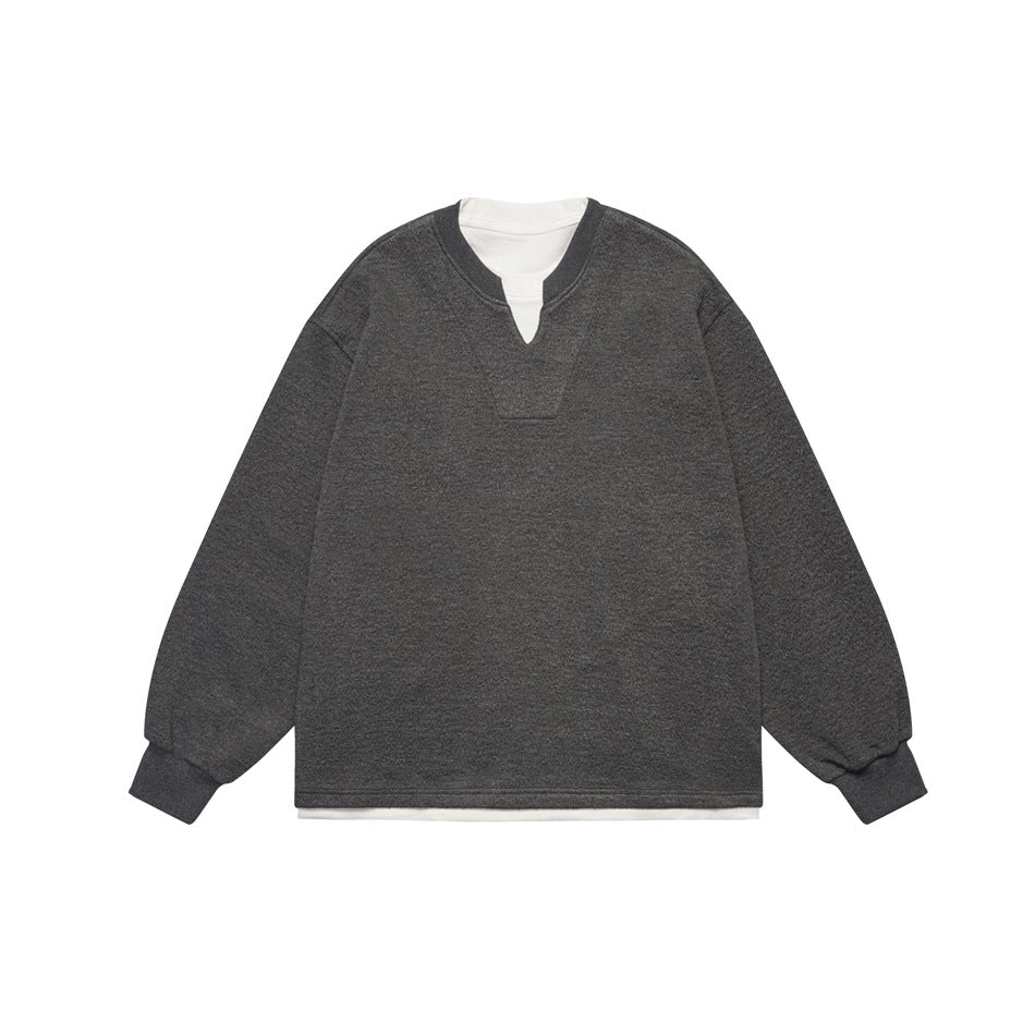 Dark charcoal gray pullover sweatshirt with notched neckline, ribbed cuffs and white layered under-hem, flat lay