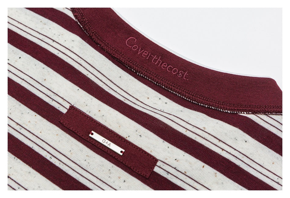 Inside neckline detail of the striped shirt, with a burgundy neckband and small sewn-on metal tag.