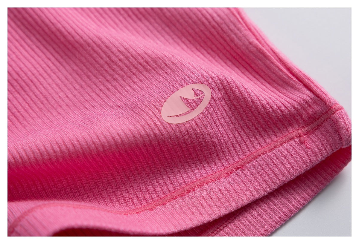 Close-up of pink ribbed fabric and hem stitching with a small oval emblem on the garment.