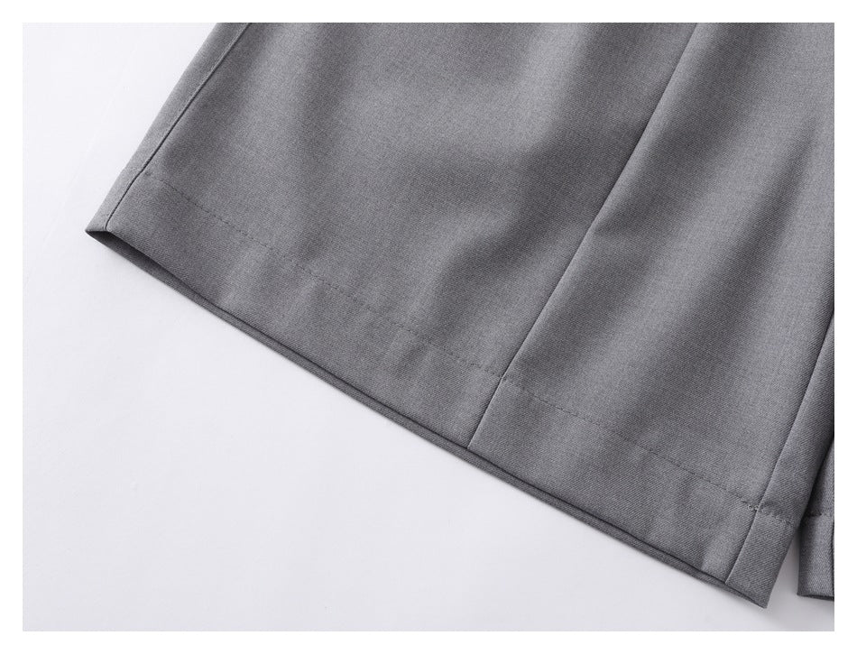 Close-up of the stitched hem on a gray shorts leg.
