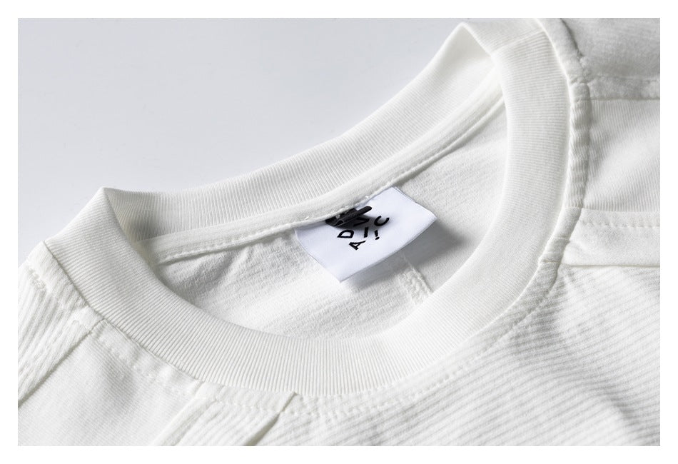 Close-up of a white ribbed crew neck and inner label with black lettering.