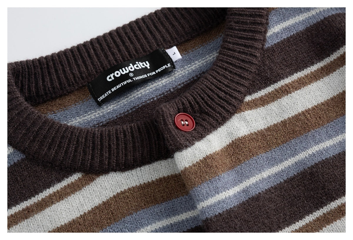 Close-up of the cardigan's dark ribbed neckline, striped knit, red button, and black woven brand label.