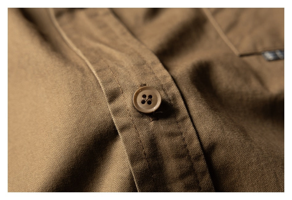 Close-up of a brown shirt button, placket stitching, and fabric texture.