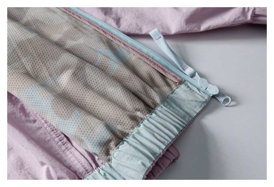 Inside view of a pale lavender jacket showing mesh lining, light blue trim, and zipper.