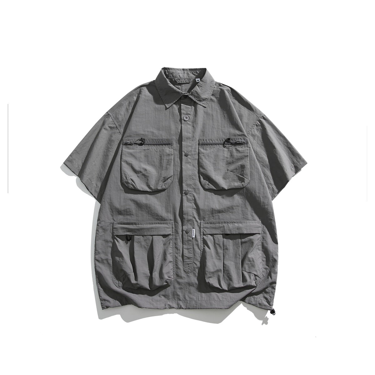 Light gray short-sleeve utility shirt flat lay with four flap pockets and button front
