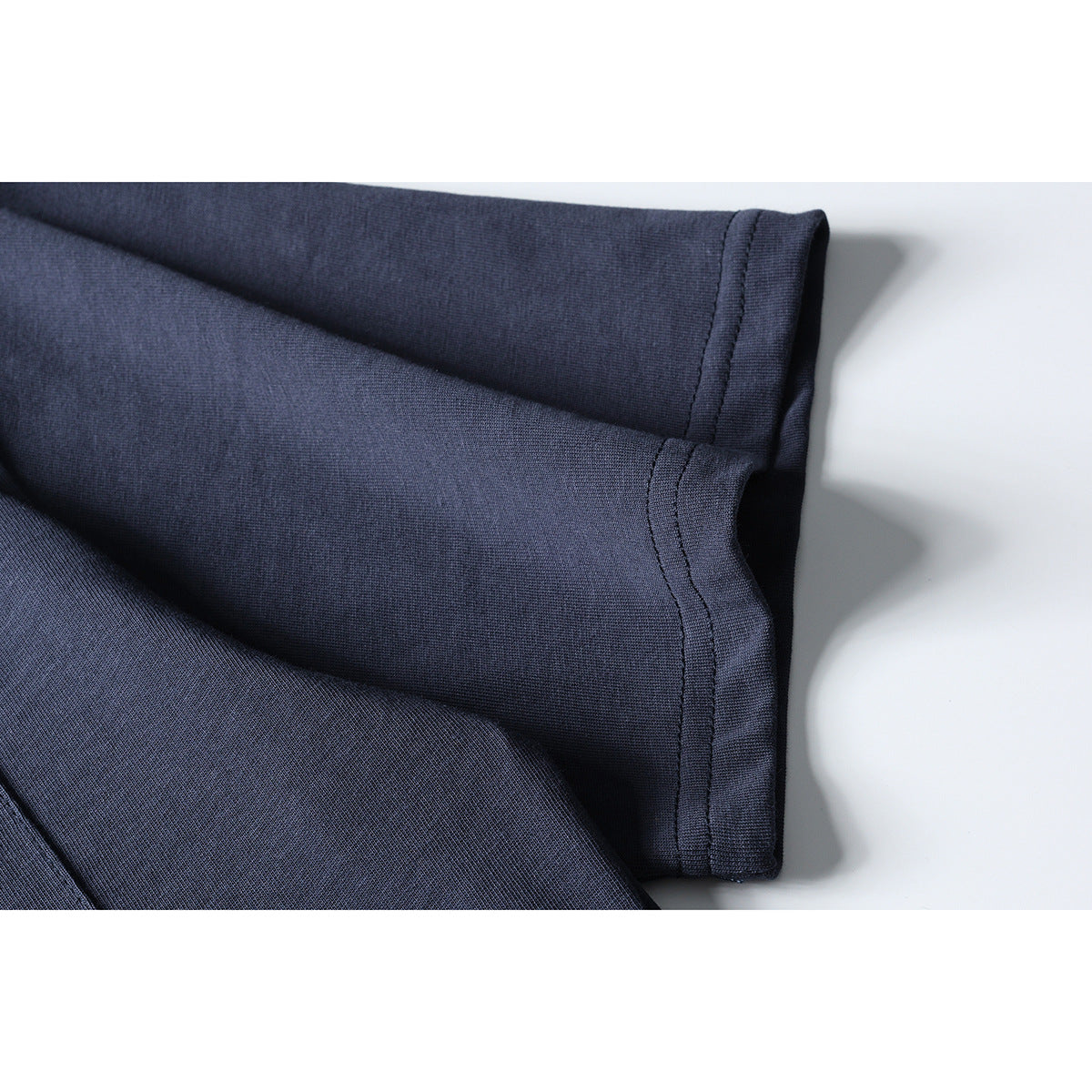 Close-up of a dark navy T-shirt sleeve and double-stitched hem.