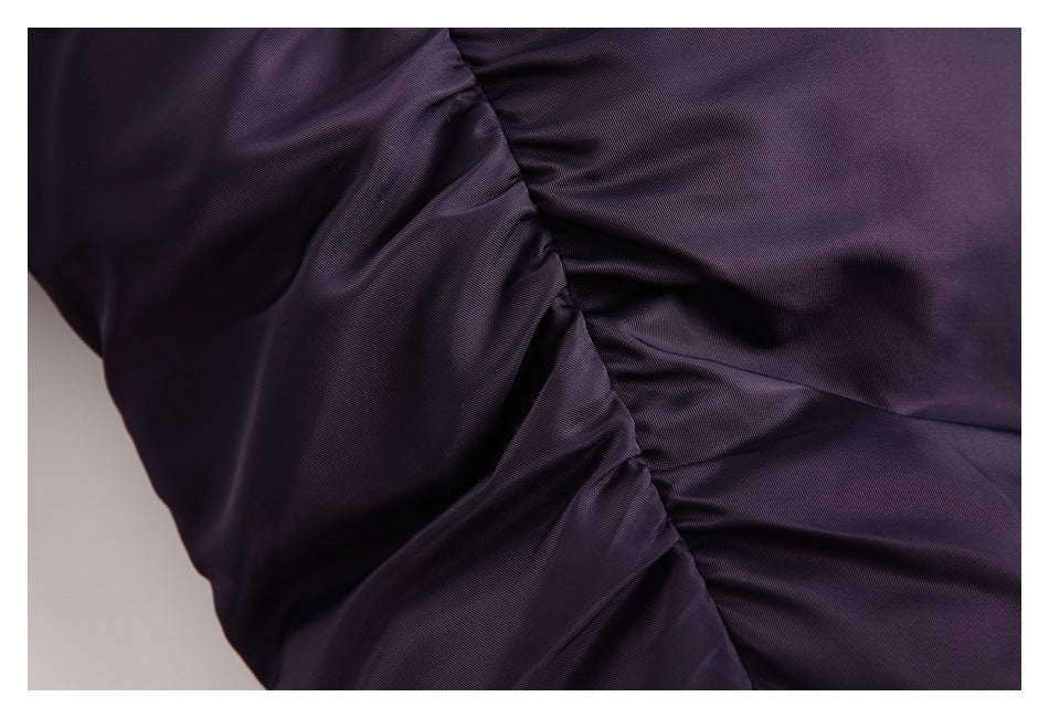 Close-up of dark purple jacket fabric gathered along a curved stitched seam.