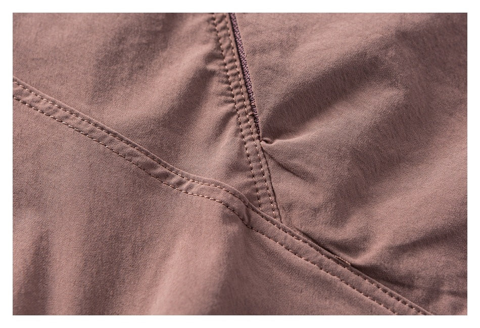 Close-up of mauve garment fabric with intersecting stitched seams.