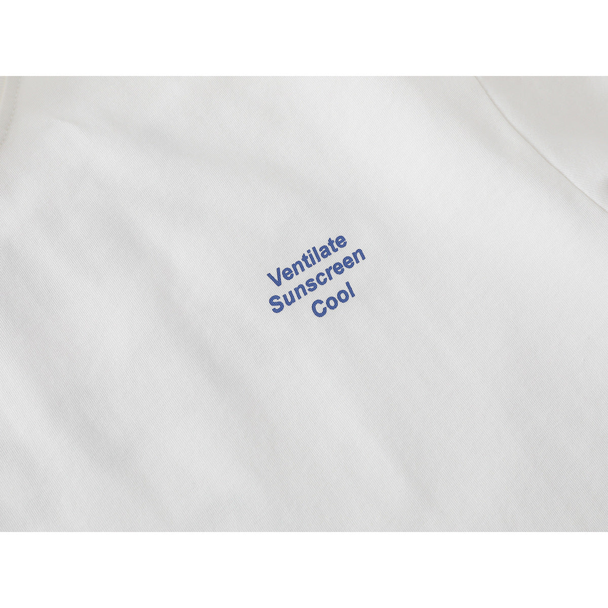 Close-up of blue “Ventilate Sunscreen Cool” lettering printed on a white T-shirt.