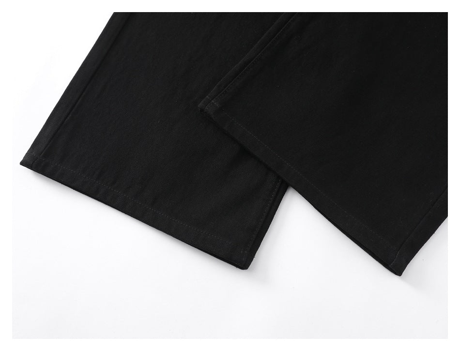 Close-up of overlapping hems on black garment panels against a white background.