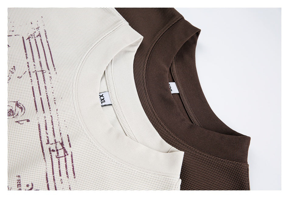 Close-up of the ribbed collars and textured fabric of off-white and brown graphic T-shirts.