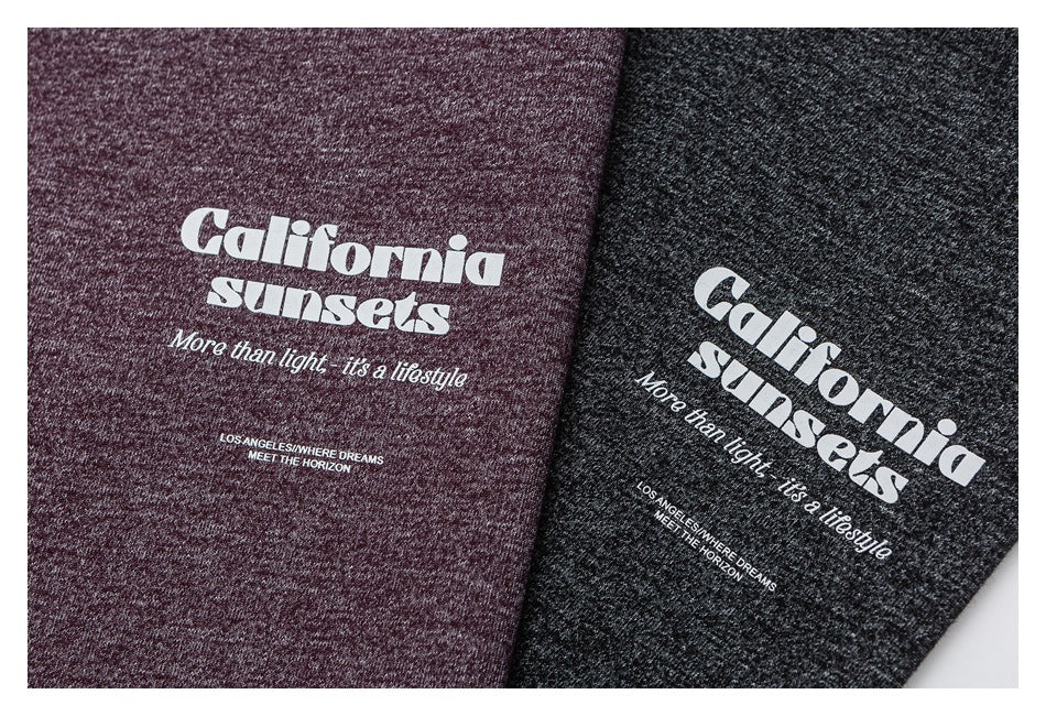 Close-up of white “California sunsets” lettering printed on burgundy and charcoal heather fabric.