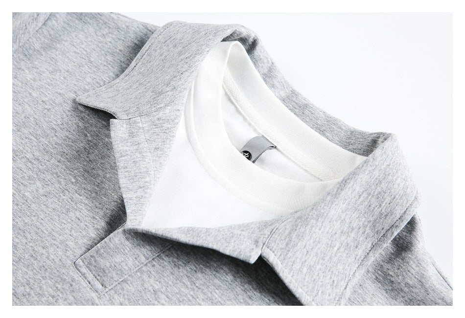 Close-up of a light gray polo shirt collar and placket, with a white inner neckline visible.