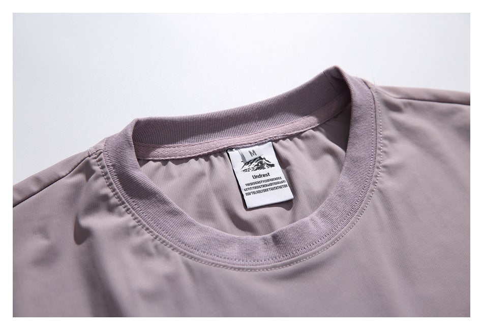 Close-up of the mauve shirt's ribbed crew neckline and sewn-in neck label.