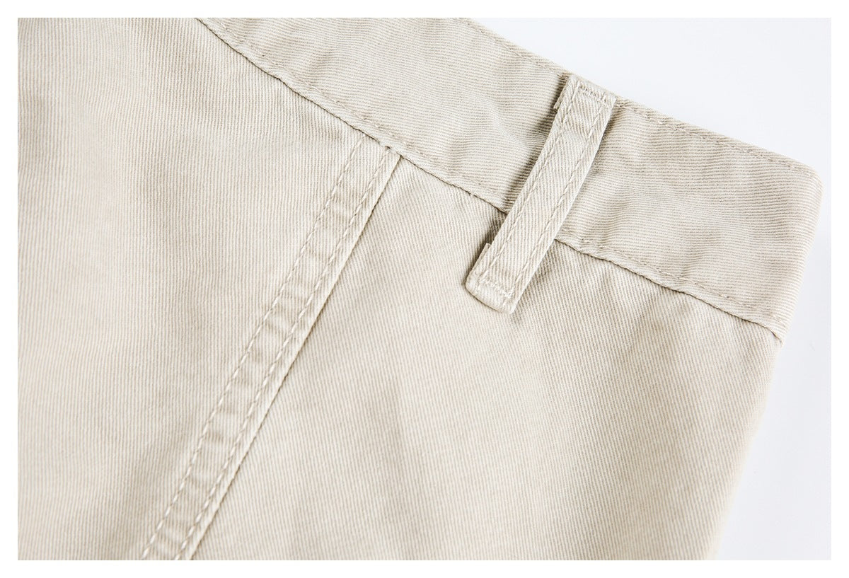 Close-up showing a belt loop and pocket seam on light beige pants.