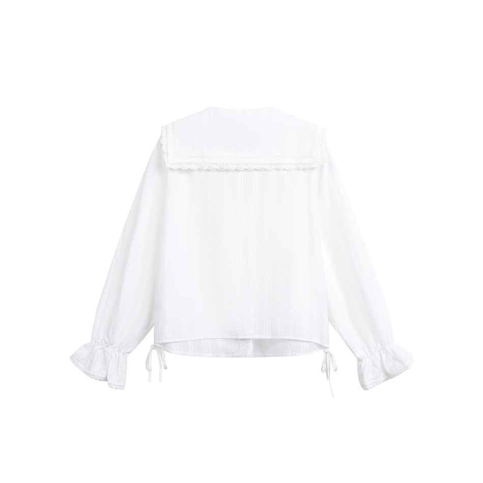 Back view of white blouse with wide lace-trimmed collar, ruffled cuffs and small ribbon ties at the hem