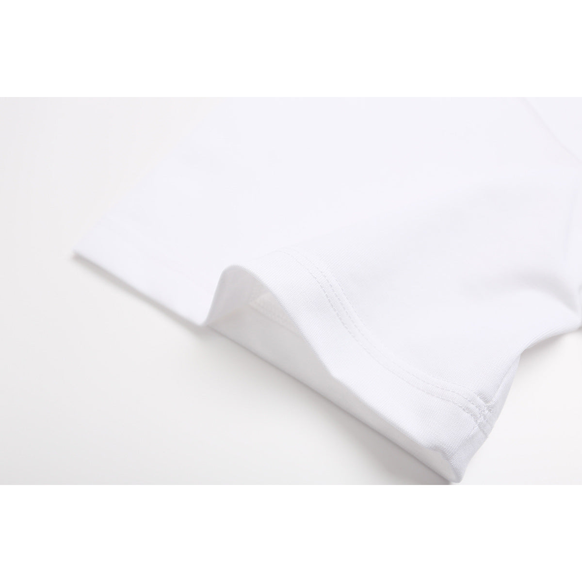 Close-up of a white T-shirt hem with double-row stitching.