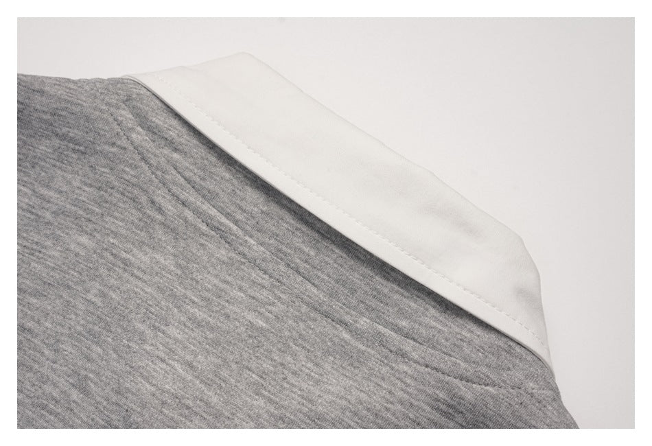 Close-up of a white collar or trim panel joined to gray knit fabric with a stitched seam.