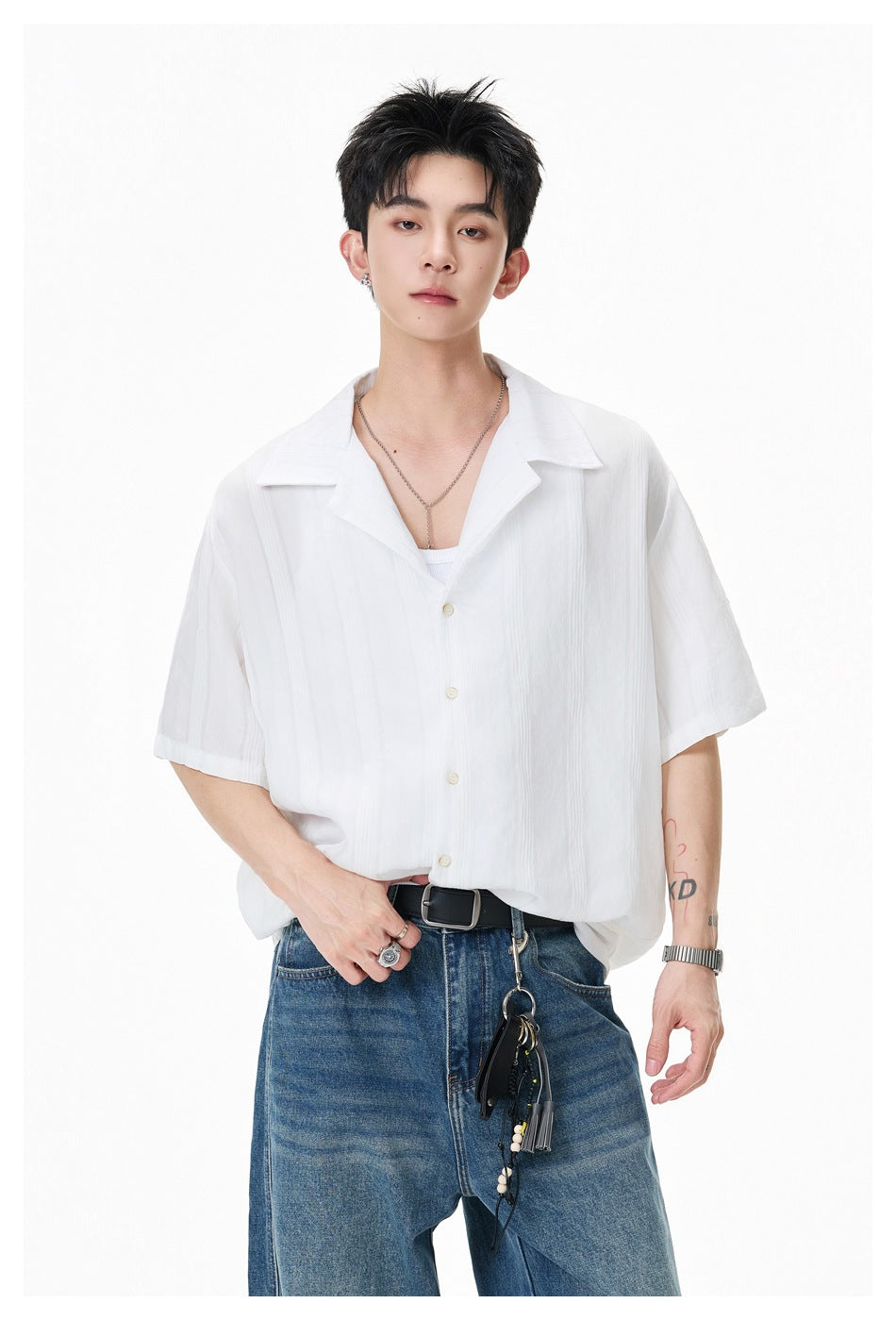 Closer front view of a model wearing a white short-sleeve collared shirt with blue jeans.