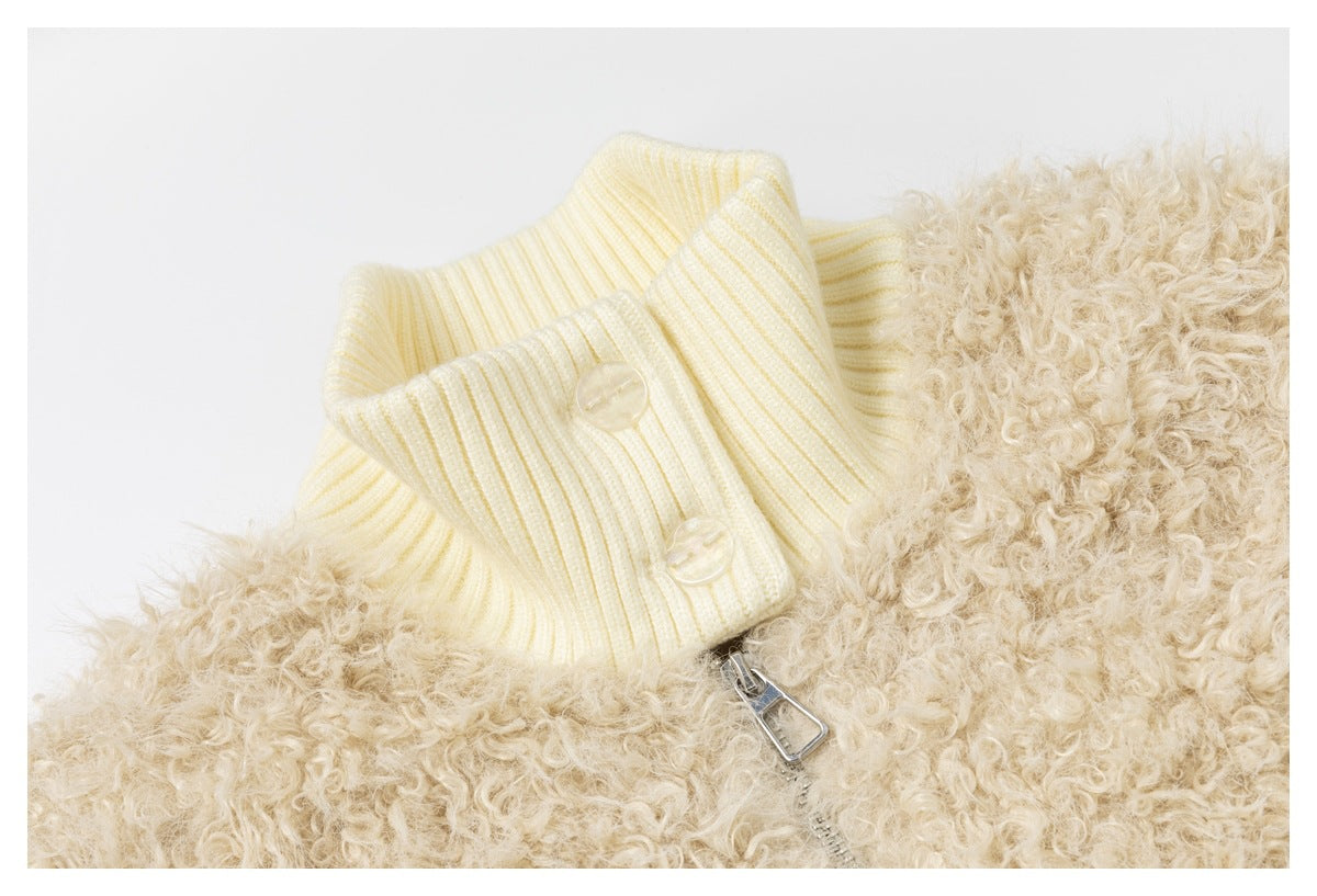 Close-up of the ivory ribbed collar, buttons and zipper pull against the shaggy beige jacket front.