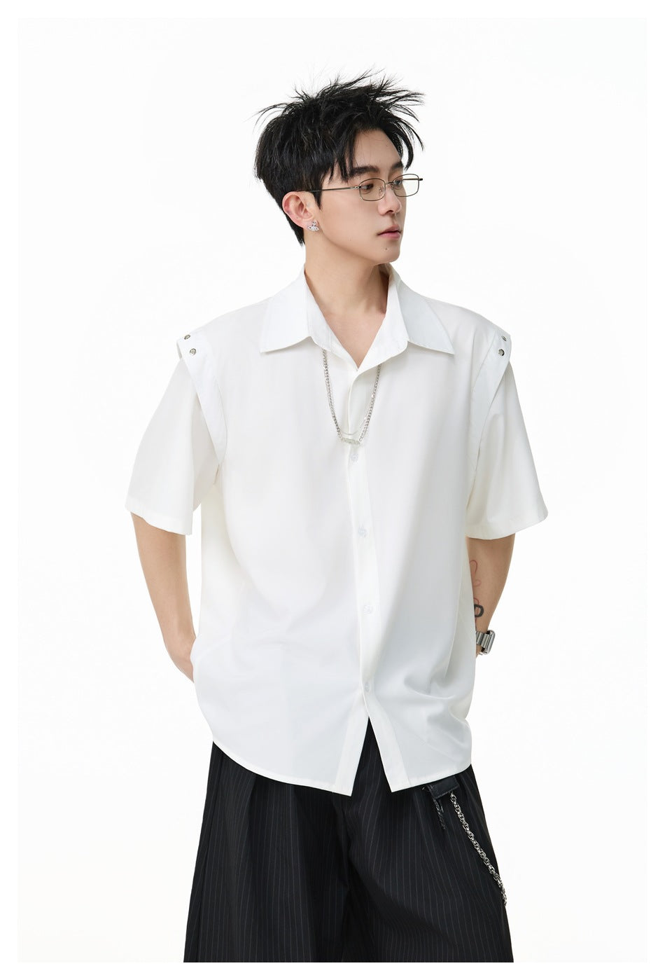 Closer view of a model wearing a white short-sleeve button-up shirt with snap shoulder details.