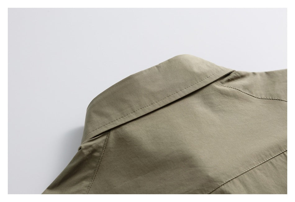 Close-up of the olive-gray garment's shoulder and stitched collar seam.