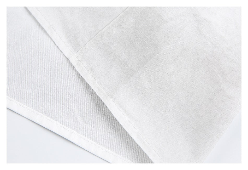 Close-up of a white garment seam and stitched hem.