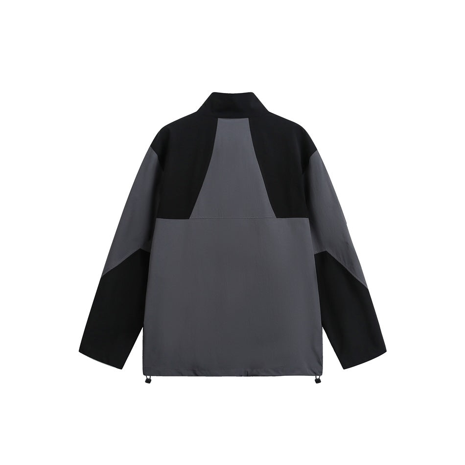 Back view of a black and charcoal-gray color-block jacket with a stand collar and long sleeves.