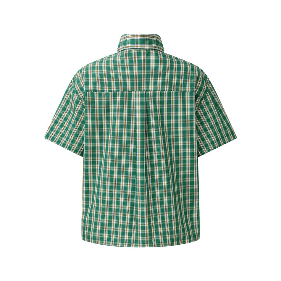 Back of a green plaid short-sleeve shirt showing yoke seam and center pleat