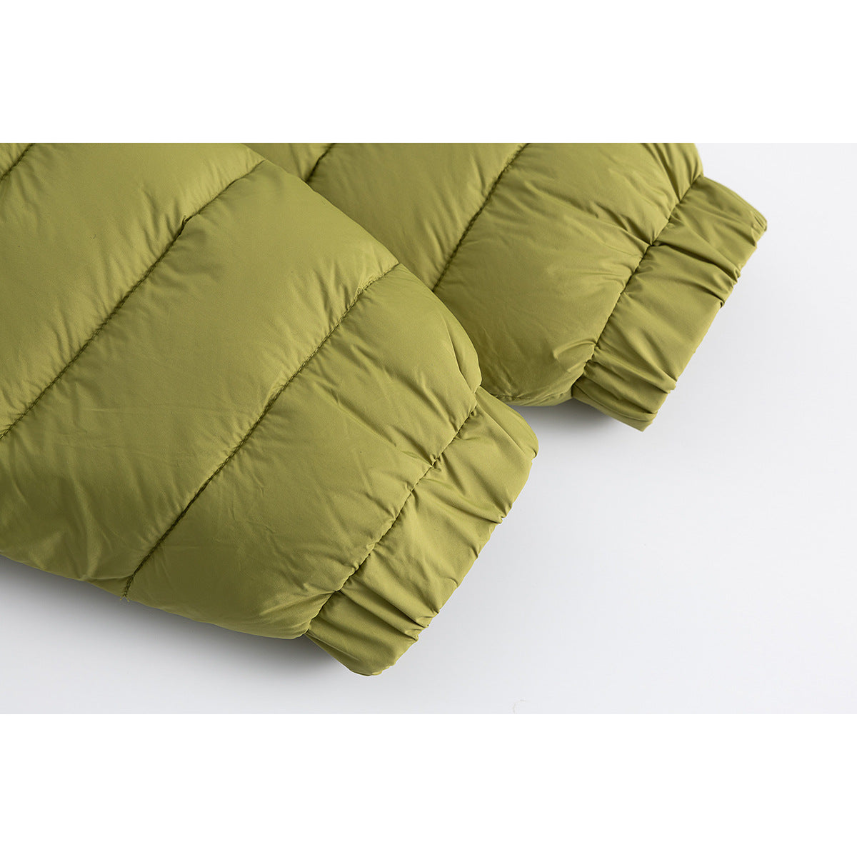 Close-up of the quilted sleeve and elastic cuff of an olive-green jacket.