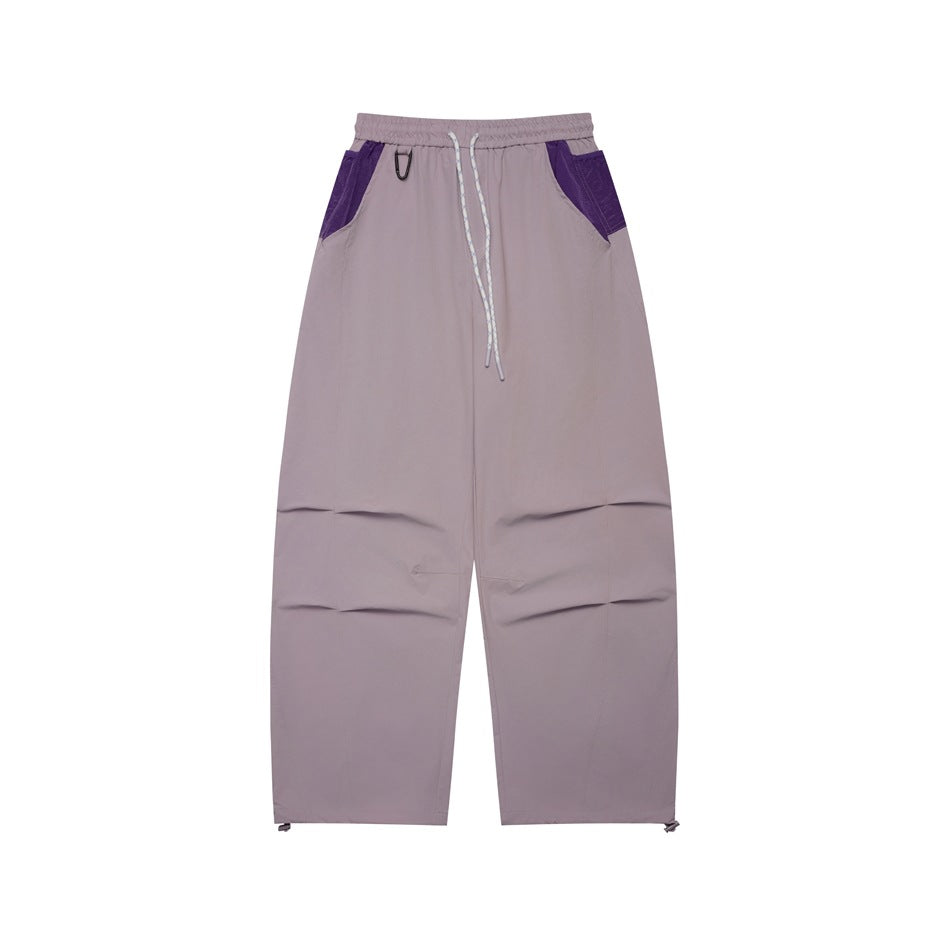 Dusty purple wide-leg drawstring pants with purple pocket panels and knee pleats, flat front view
