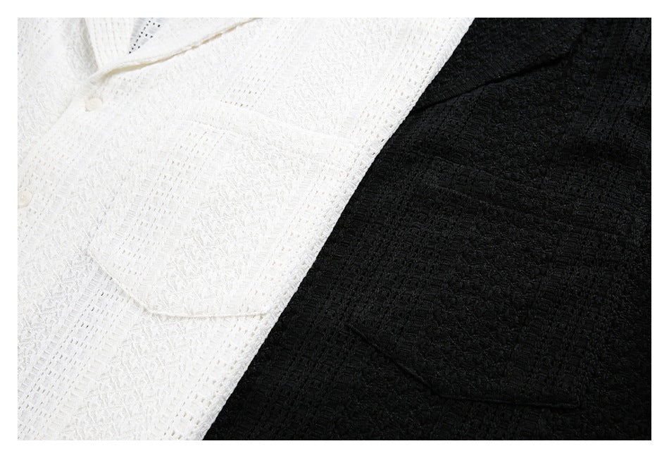 Close-up of the textured white and black tunic fabric and a white button.