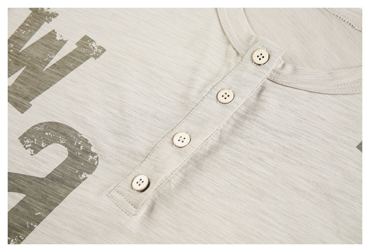 Close-up of a cream shirt’s four-button placket and distressed graphic print.
