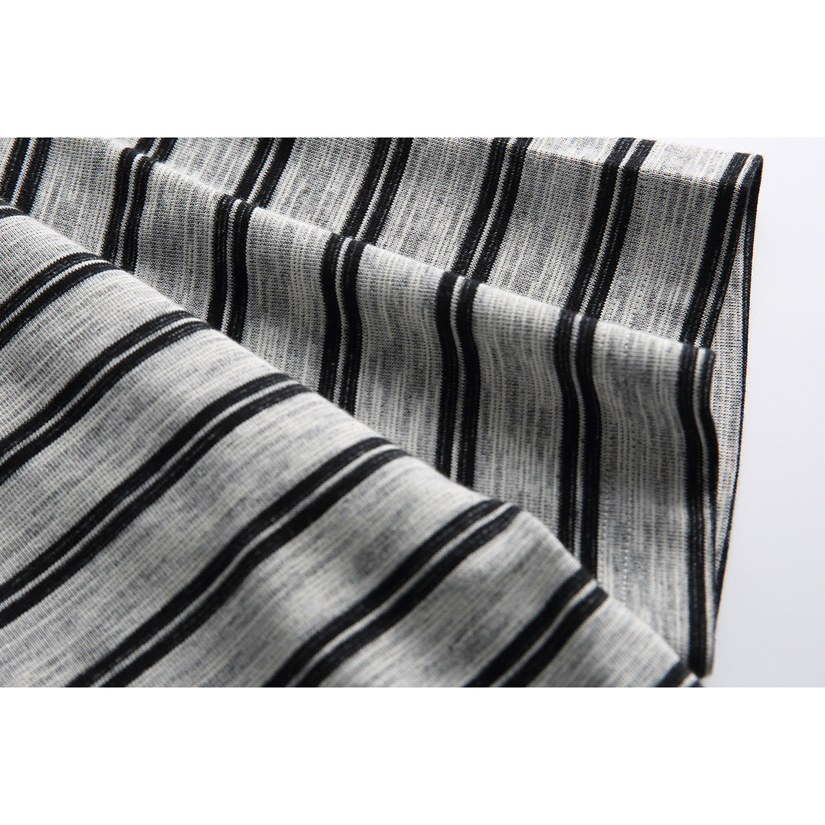 Close-up of gray-and-black striped shirt fabric folded to show its pattern and knit texture.