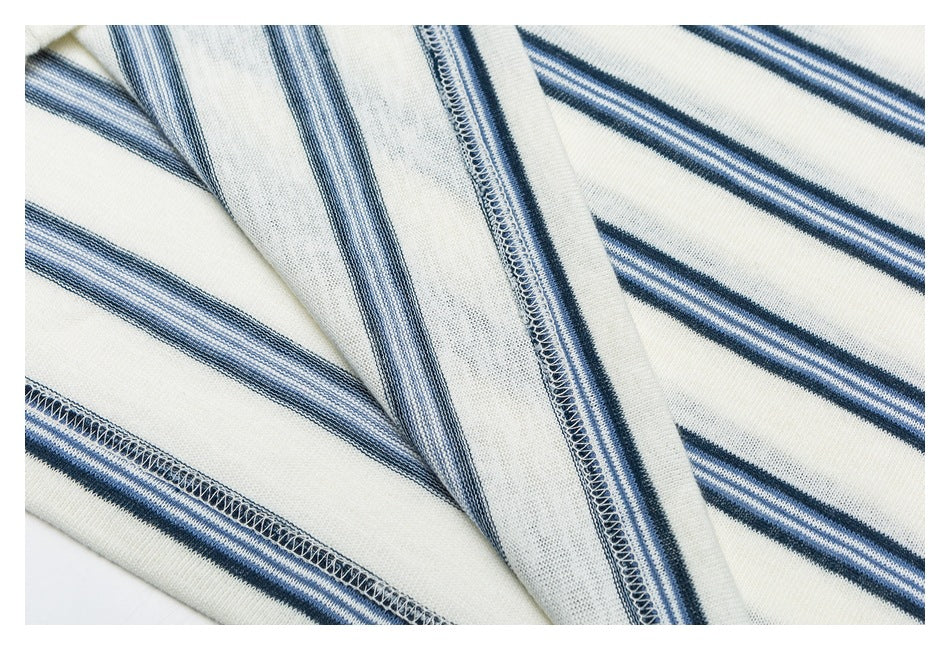 Close-up of overlocked seams and striped ivory knit fabric.