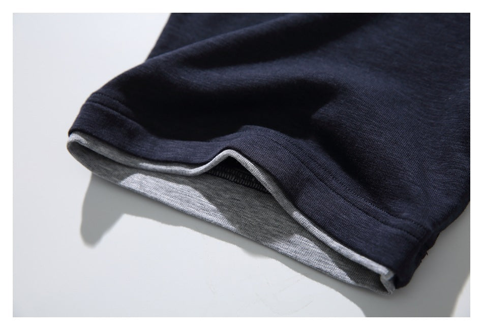 Close-up of a dark navy garment hem with a contrasting gray inner layer and visible stitching.