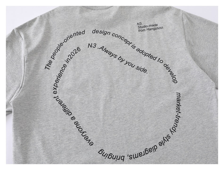 Flat-lay front of a light gray crew-neck T-shirt with a circular black English text graphic.