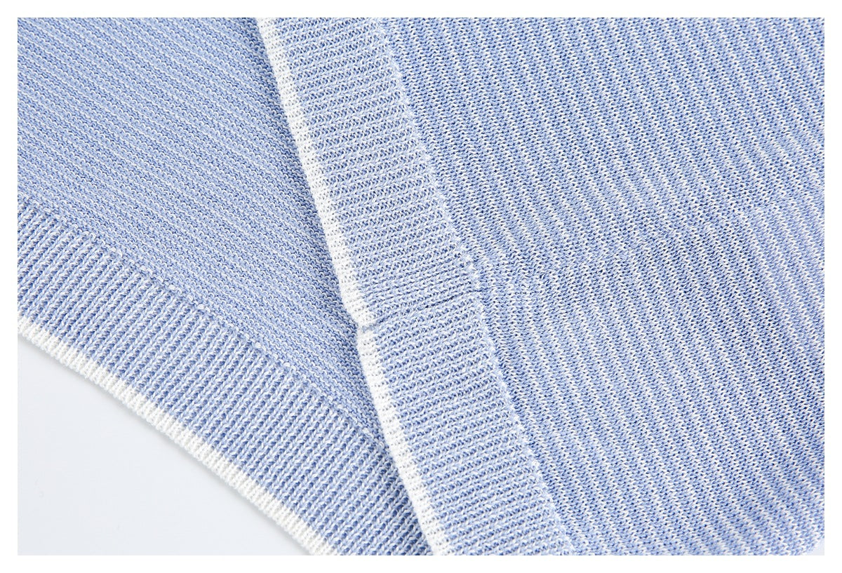 Close-up of blue-and-white heathered knit fabric and a wide ribbed garment edge.