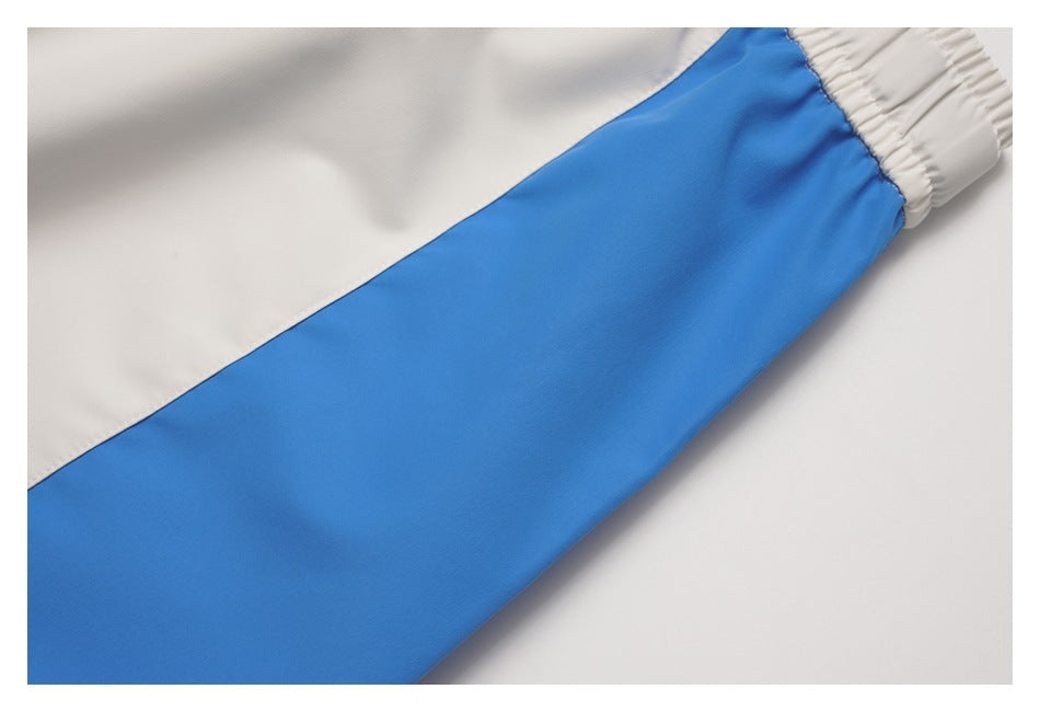 Close-up of a bright blue pant leg panel meeting white fabric and an elastic cuff.