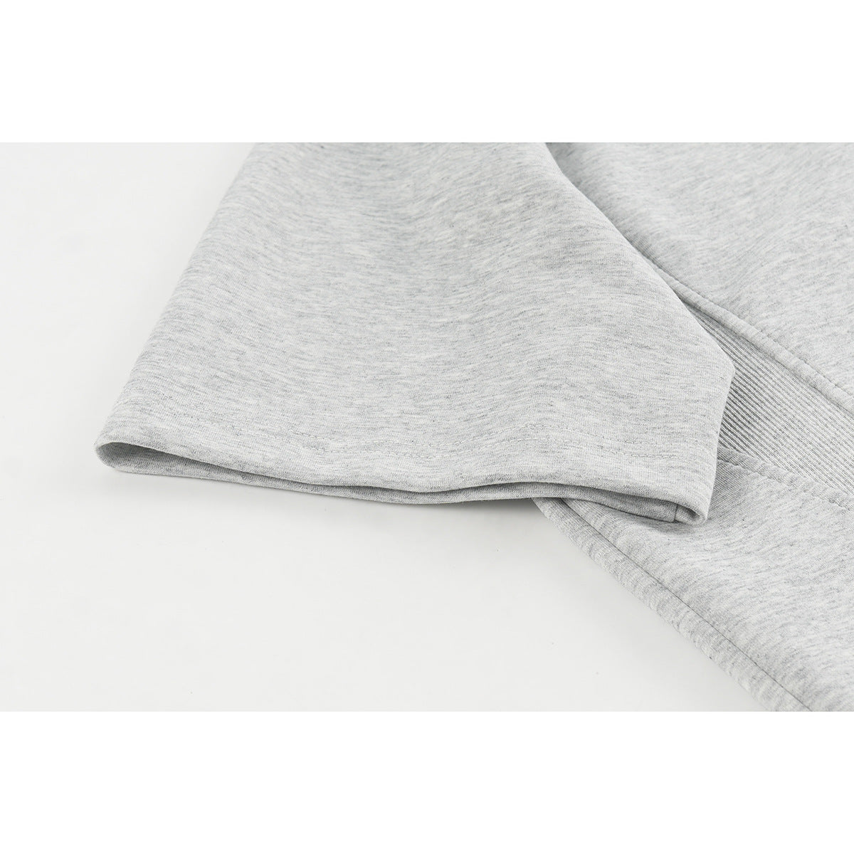 Close-up of a heather gray short sleeve and its stitched hem.