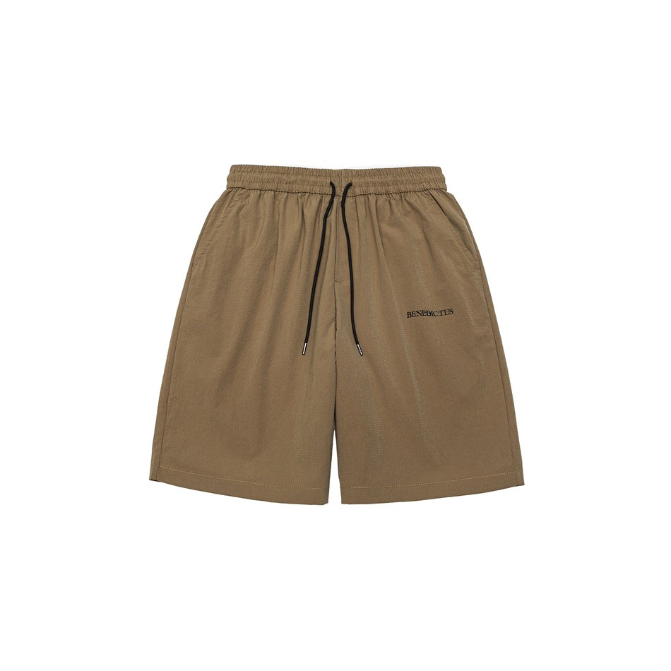 Khaki knee-length shorts with elastic drawstring waist, side pockets and small embroidered text, front view flat lay