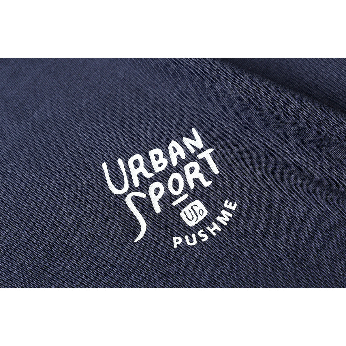 Close-up of white “Urban Sport” graphic lettering printed on navy fabric.