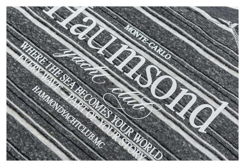 Close-up of white decorative English lettering printed on charcoal gray striped fabric.